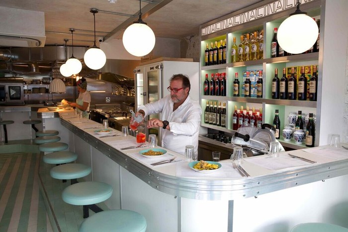 Lina Stores Soho Restaurant Review A man behind a counter pouring a drink