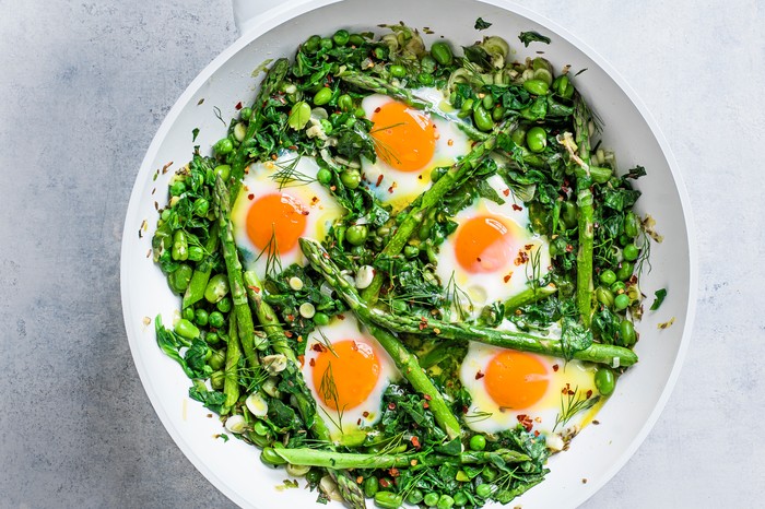 Green shakshuka in a white pan