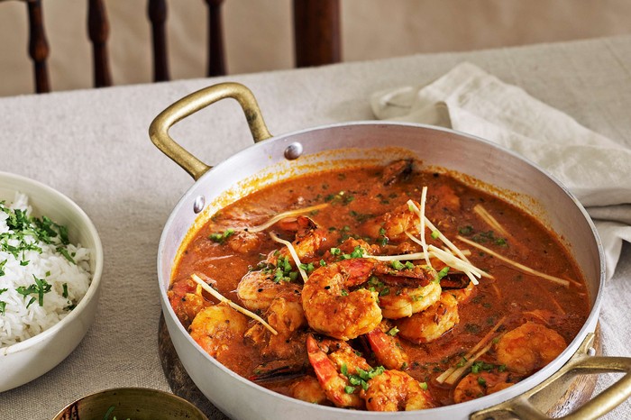 A prawn curry in a wide casserole pan with rice on the side