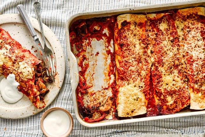 Chicken enchiladas in a baking tray and on a dish