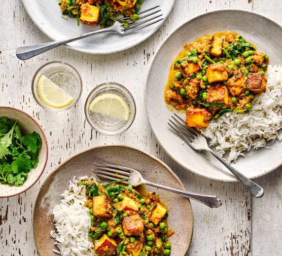 Healthy Paneer Curry Recipe Two plates of paneer curry with rice, with forks and two glasses of water with lemon wedges