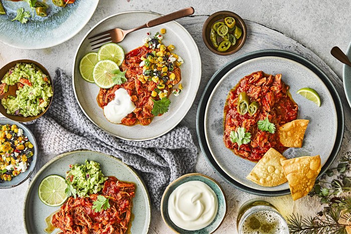 three plates of chicken Tinga with salsa and tortilla chips