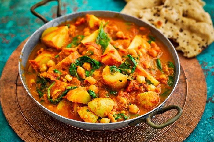 Spinach, Chickpea and Potato Curry Recipe Spinach, chickpea and potato curry in a skillet with some naan breads