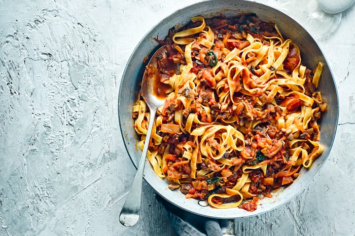 A large silver pot full of vegan bolognese with mushrooms