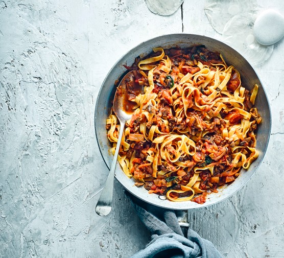 Vegan Bolognese Recipe A large silver pot full of vegan bolognese with mushrooms