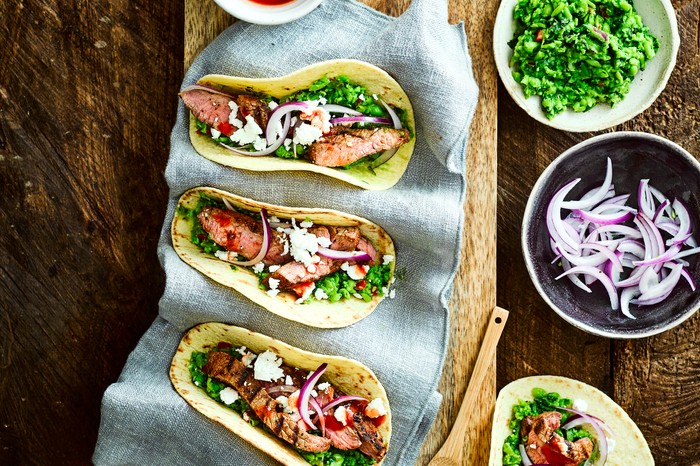 Lamb tacos with minted pea guacamole, feta and onion