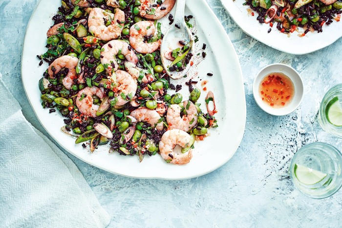 Black rice salad recipe with prawns and edamame on a white serving plate