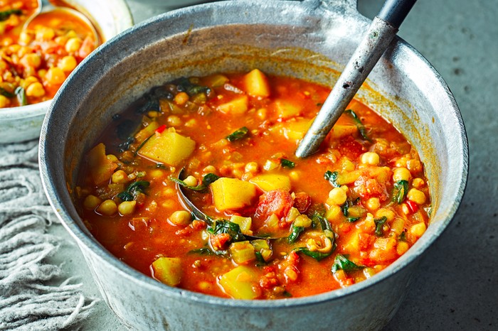 Moroccan veggie soup in a large silver pot with a silver serving spoon