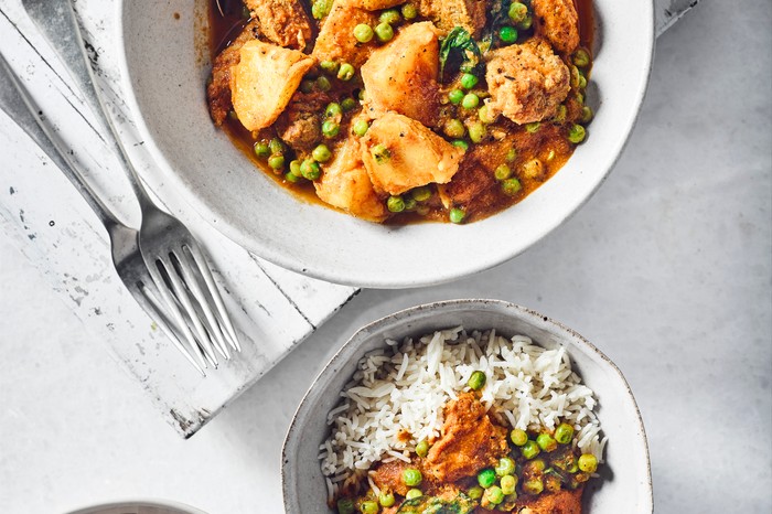 Three bowls of pork vindaloo, two with rice