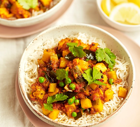 Two Bowls of Courgette Curry on a Bed of Rice