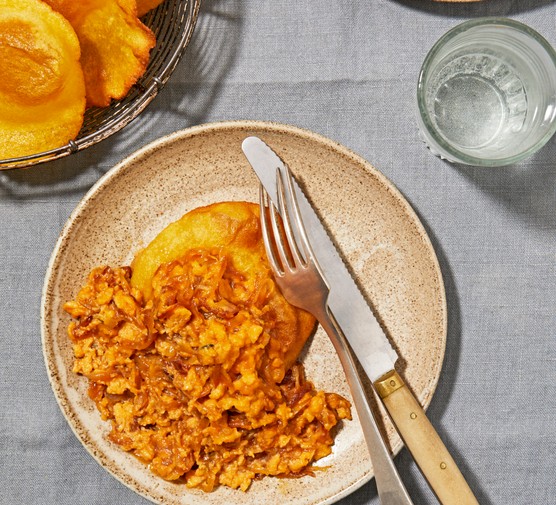 Spanish scrambled eggs A brown plate topped with fried tortillas and orange scrambled eggs