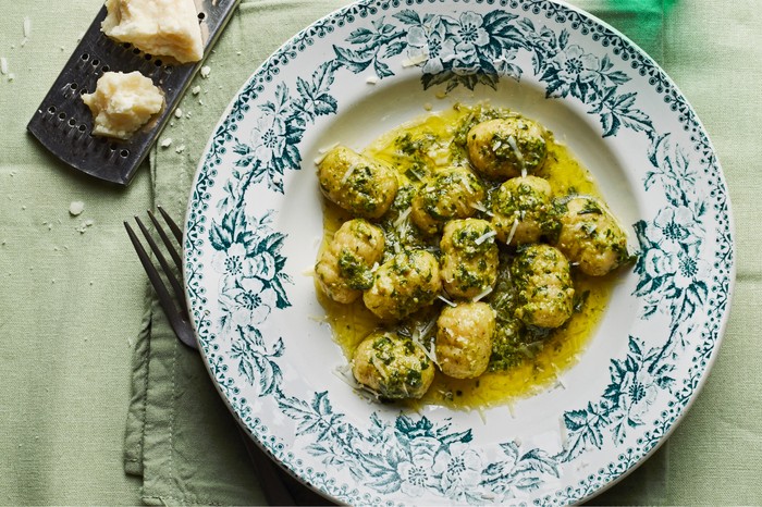 Patterned bowl filled with gnocchi topped with wild garlic pesto