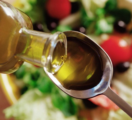 Olive oil pouring on to a spoon