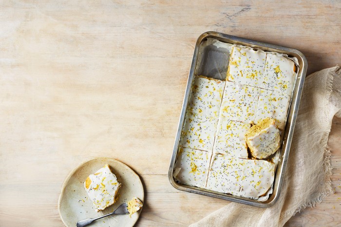 A frosted sheet cake with one slice taken out of it