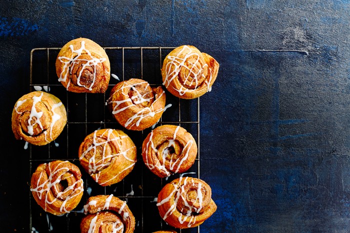 Croissant cinnamon rolls 12 croissant cinnamon rolls served on a cooling rack on a dark blue board