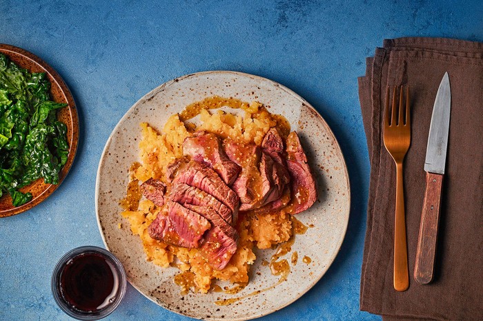 A plate of venison with crushed swede on a small plate