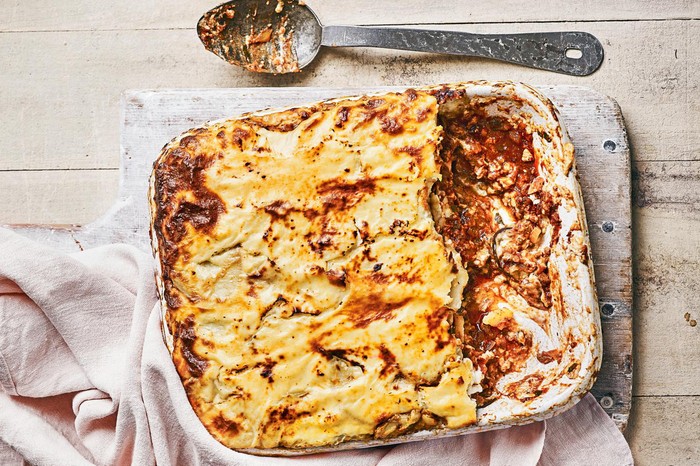 vegetarian moussaka in a baking dish with two slices missing