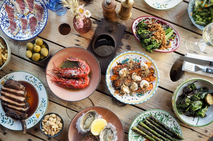 Artist Residence, Brighton A selection of fish and veggie small plates on a wooden table served at Artist Residence in Brighton