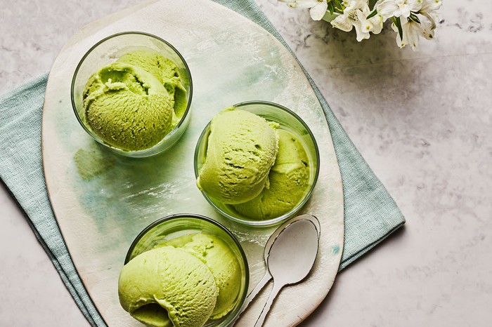 Three glass bowls of green ice cream