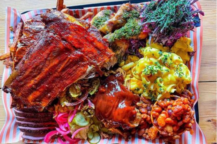 A platter for four from Big Nath's BBQ, including brisket, pulled pork, chimichurri chicken, mac and cheese and purple slaw