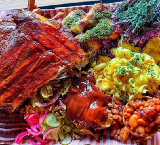 A platter for four from Big Nath's BBQ, including brisket, pulled pork, chimichurri chicken, mac and cheese and purple slaw