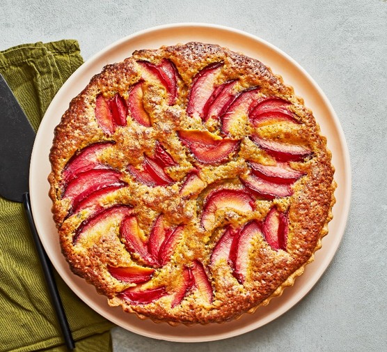 20 plum recipes A plum tart on a peach plate with an olive green napkin