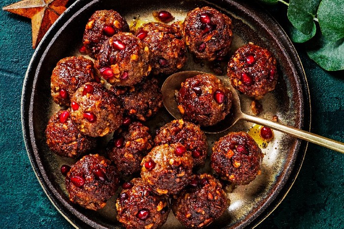 A black bowl of stuffing balls on a greed background