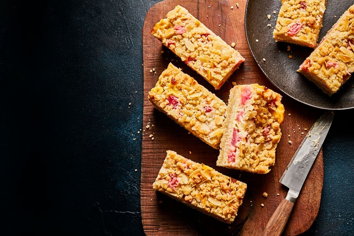 Rhubarb and custard crumble bars on a wooden board and slate plate