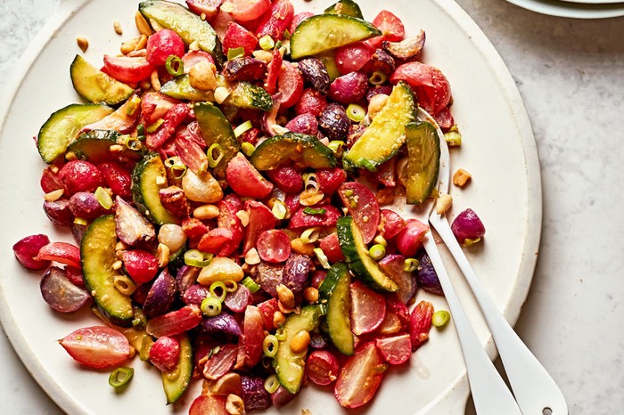 Large plate of radishes, peanuts, cucumber, tomato and spring onions