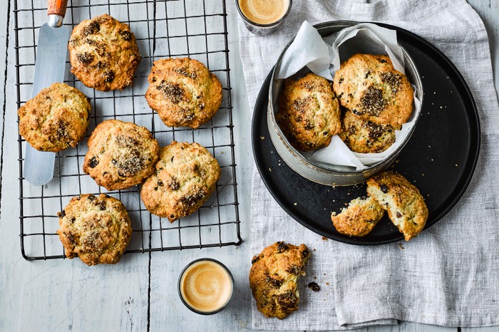 Rock Cakes Recipe Rock Cakes on a cooling tray with two mugs of coffee