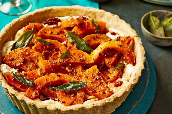 A whole butternut squash tart with crispy sage leaves on top