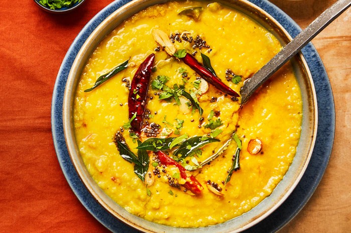 Dhal in a pot topped with chilli, coriander and oil