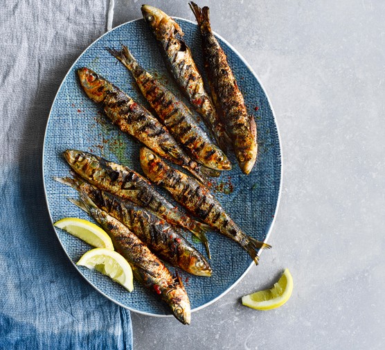 Grilled Portuguese Sardines Recipe Grilled Portuguese Sardines served on an oval blue plate