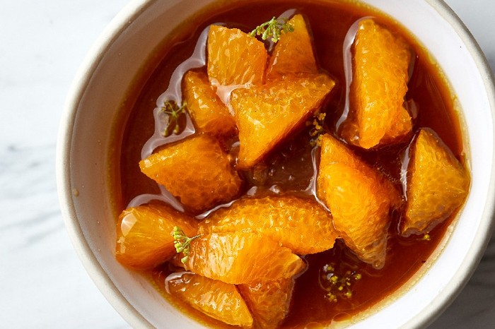 A white ramekin filled with chocolate mousse with orange segments on top