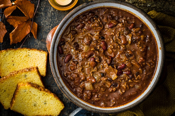 A large pot of slow-Cooker beef chilli, served with Jalapeño cheddar cornbread