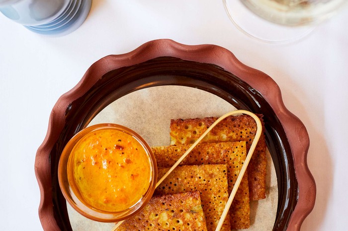 Square-shaped savoury pancakes on a plate with dip on the side