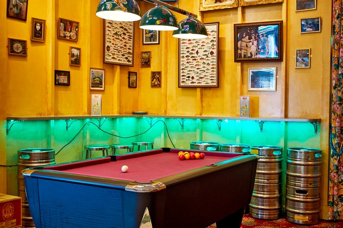 The pool table and decorative wall art in Speedboat Bar in Chinatown