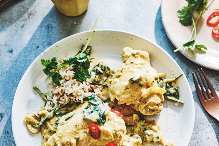 A plate of yogurt chicken with salad on the side