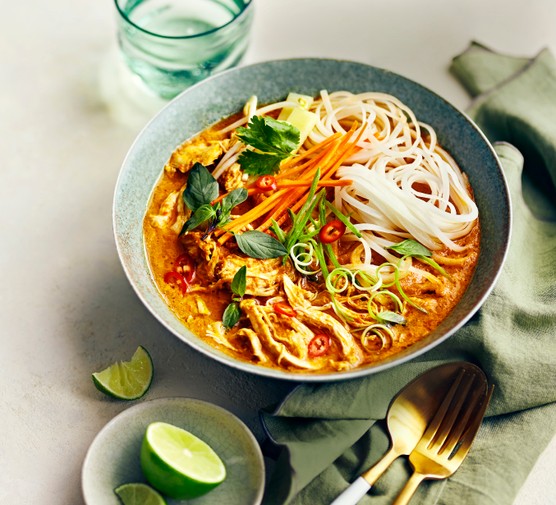 Bowl of Coconut Chicken Soup with Noodles and Fresh Lime