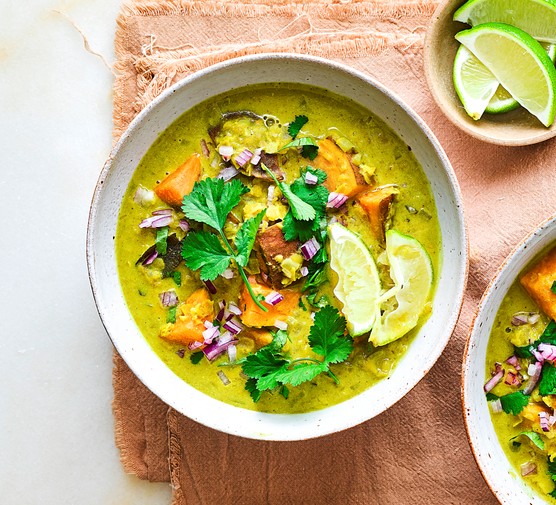 Bowls of sweet potato and lentil curry topped with coriander and lime