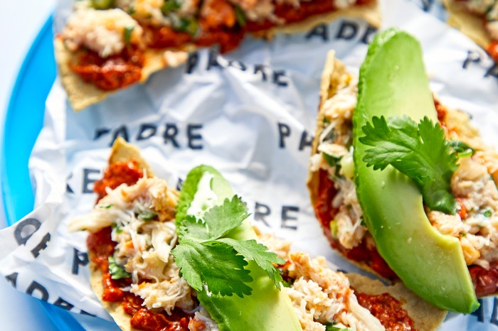 A bright blue plate with crab tostadas on top of it