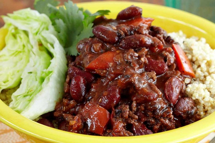 Chilli con carne with lettuce and rice in a yellow bowl