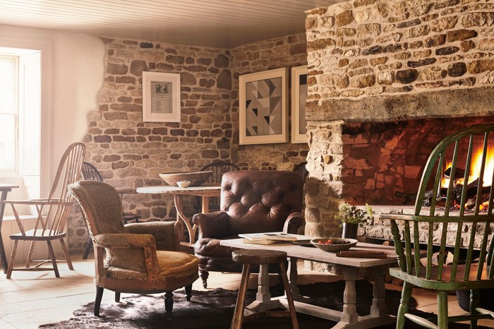 A roaring fire and squidgy leather chairs in the pub area of the Wild Rabbit, Kingham