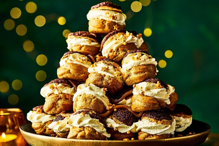 A Tiramis-choux tower on a cake stand with a green background