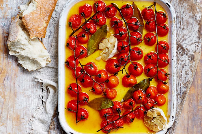 Cherry tomatoes on the vine in a roasting tin