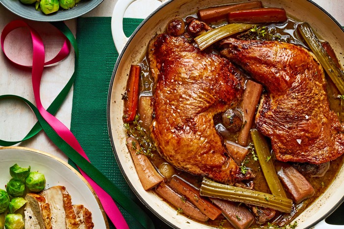 A turkey dish in a large pot with a Christmas dinner on the side