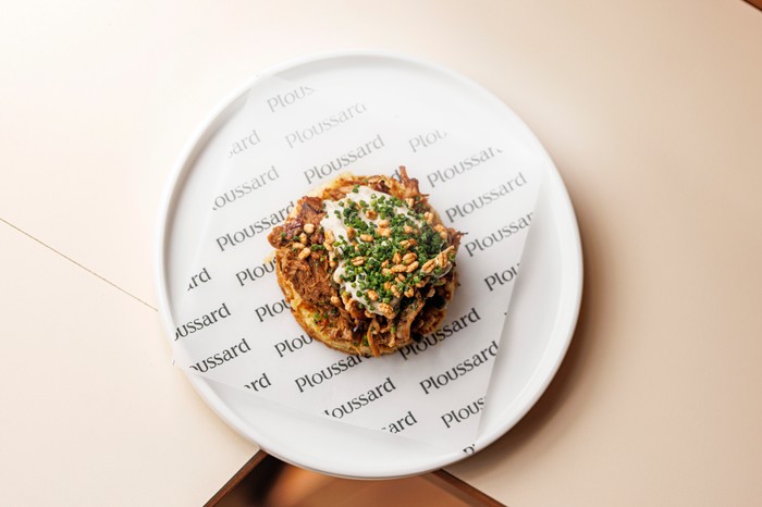 A sophisticated crumpet with toppings on a small white plate