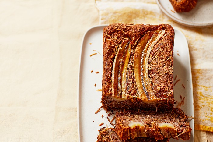 A loaf of banana bread with two slices ready to serve