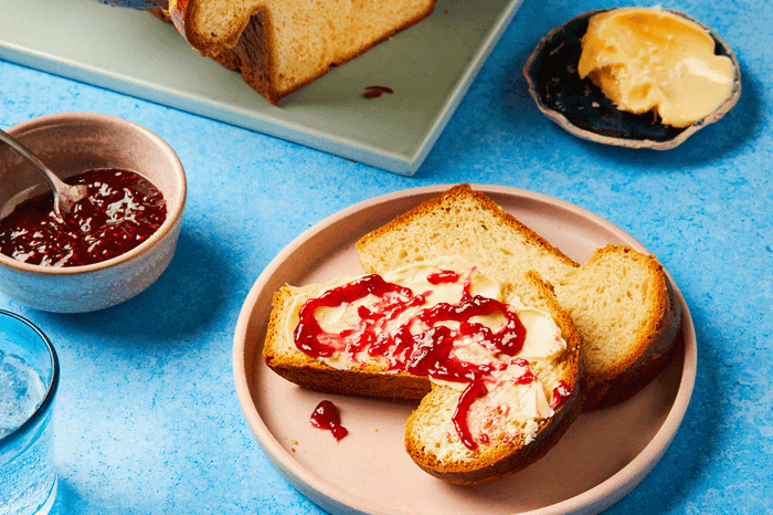 Brioche loaf with a slice cut out topped with jam