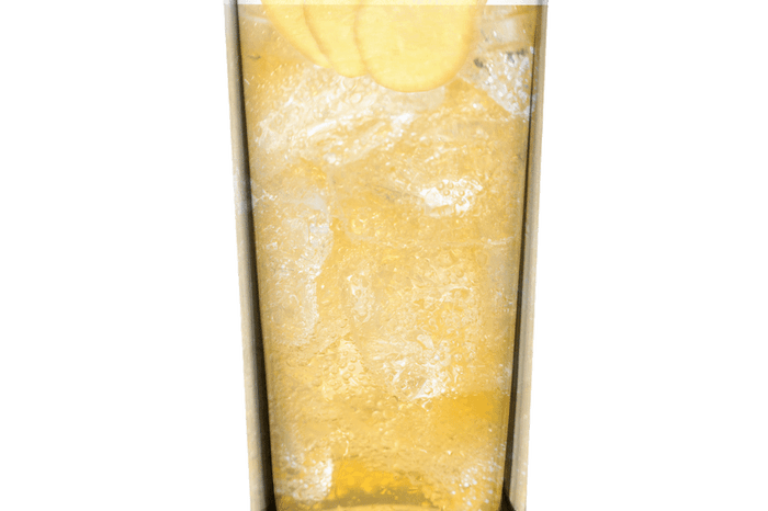 Earl grey and marmalade cooler in a tall glass with cubes of ice and slices of ginger